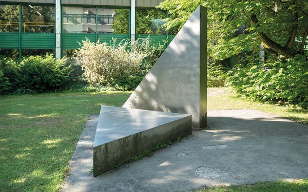 Das Foto zeigt zwei Steindreiecke. das eine liegt auf dem Boden und das andere steht in schräger Position zum ersten.