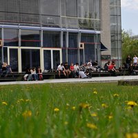 Studierende sitzen draußen vor der Bibliothek