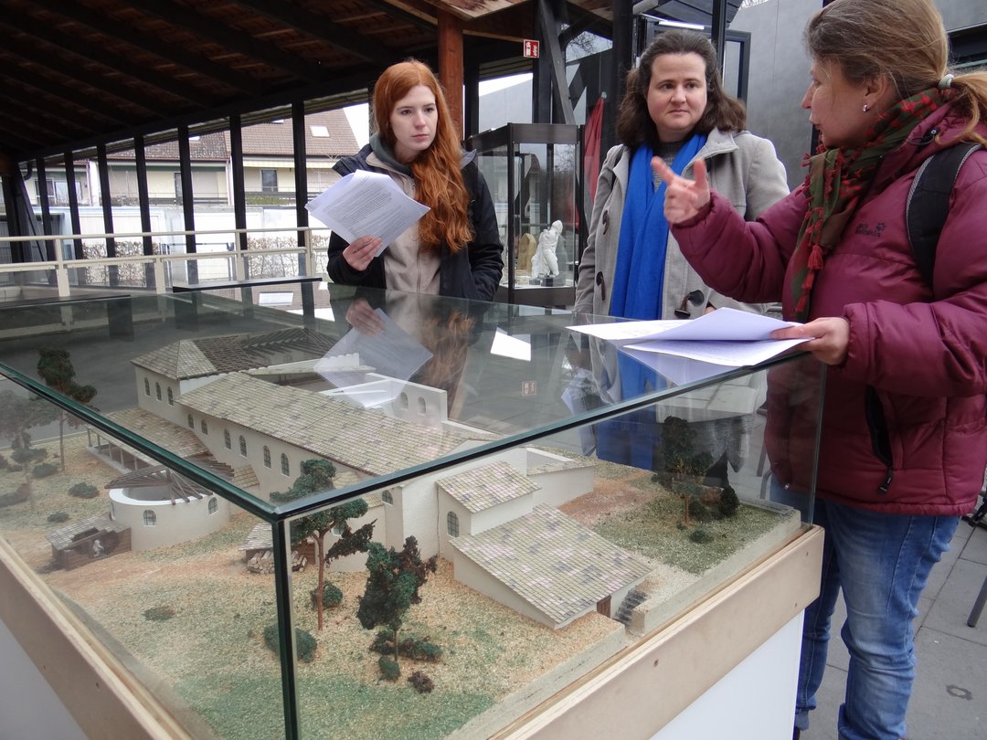ExkursionsteilnehmerInnen an einem Modell der römischen Thermen von Weißenburg in Bayern.
