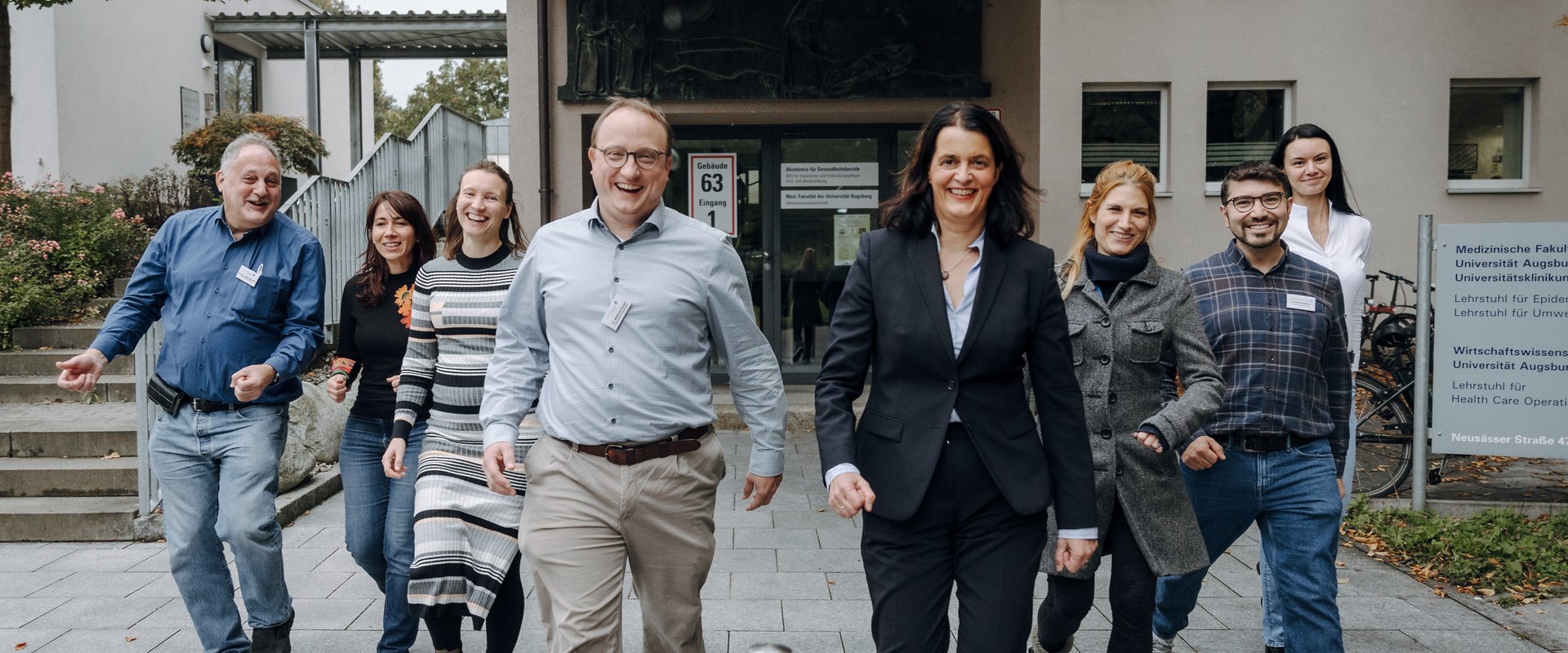 Die PIs laufend und lachend vor dem Institutsgebäude