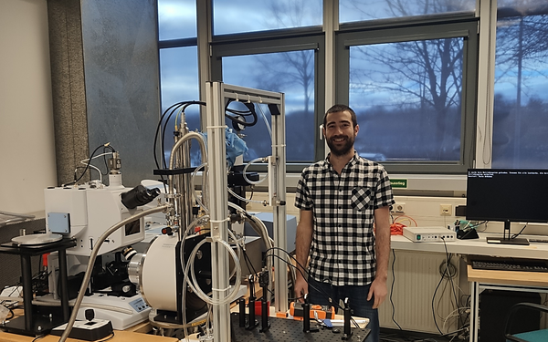 Dr. Felix Schilberth in his laboratory in front of a research setup.