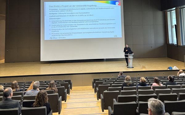 Foto des Abschlussevents des KodiLL-Projekts mit Projektsprecher Prof. Dr. Ingo Kollar und interessierten Teilnehmenden im Auditorium der Universit?t Augsburg