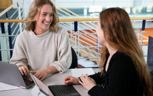 Zwei Frauen tauschen sich vor einem Laptop aus