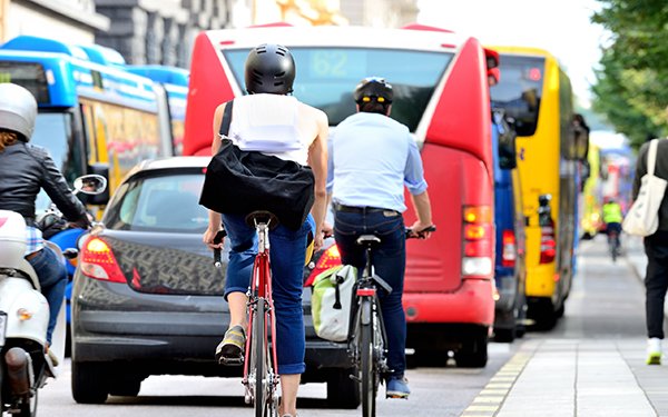 Unterschiedliche Verkehrsteilnehmer auf Rädern, im Bus und zu Fuß