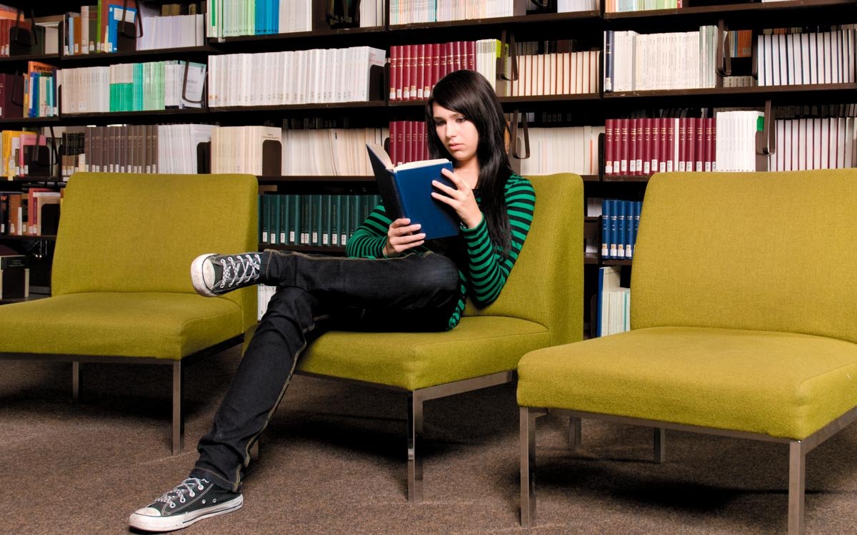 Studentin lesend in der Bibliothek