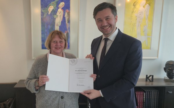 Die Pr?sidentin der Universit?t Augsburg, Prof. Dr. Sabine Doering-Manteuffel, ��berreicht dem 40-j?hrigen Theologen die Ernennungsurkunde f��r seine neue Aufgabe.