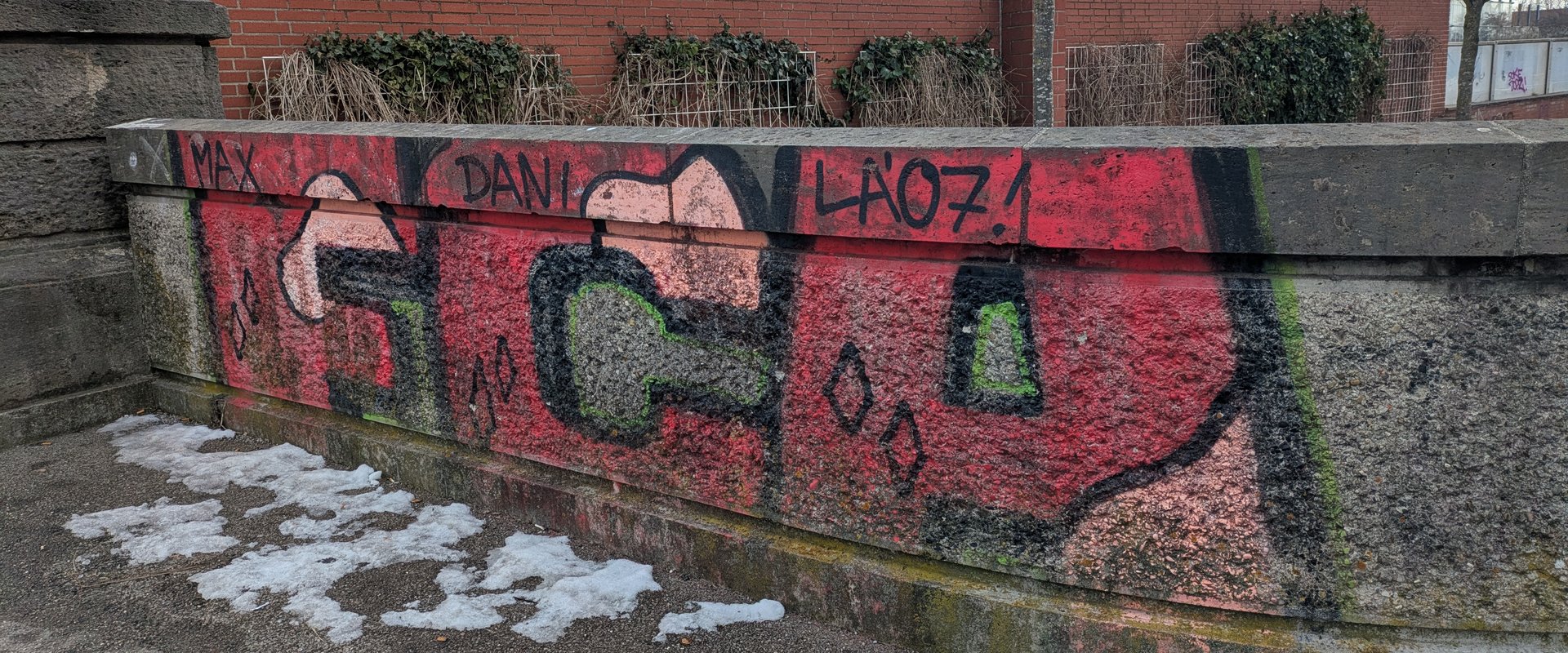 Auf einer Mauer ein Pink/Rosa FCA Schriftzug als Grafiti