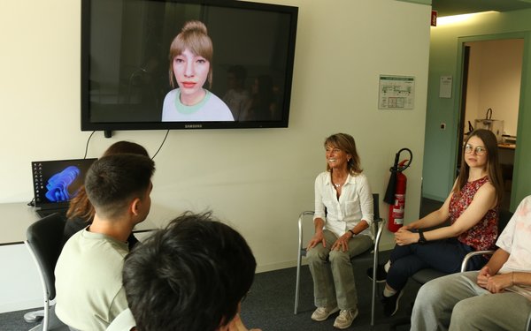 Prof. Cristina Conati vor einem Bildschirm im Gespräch mit Mitarbeitenden des Lehrstuhls für Menschzentrierte Künstliche Intelligenz.
