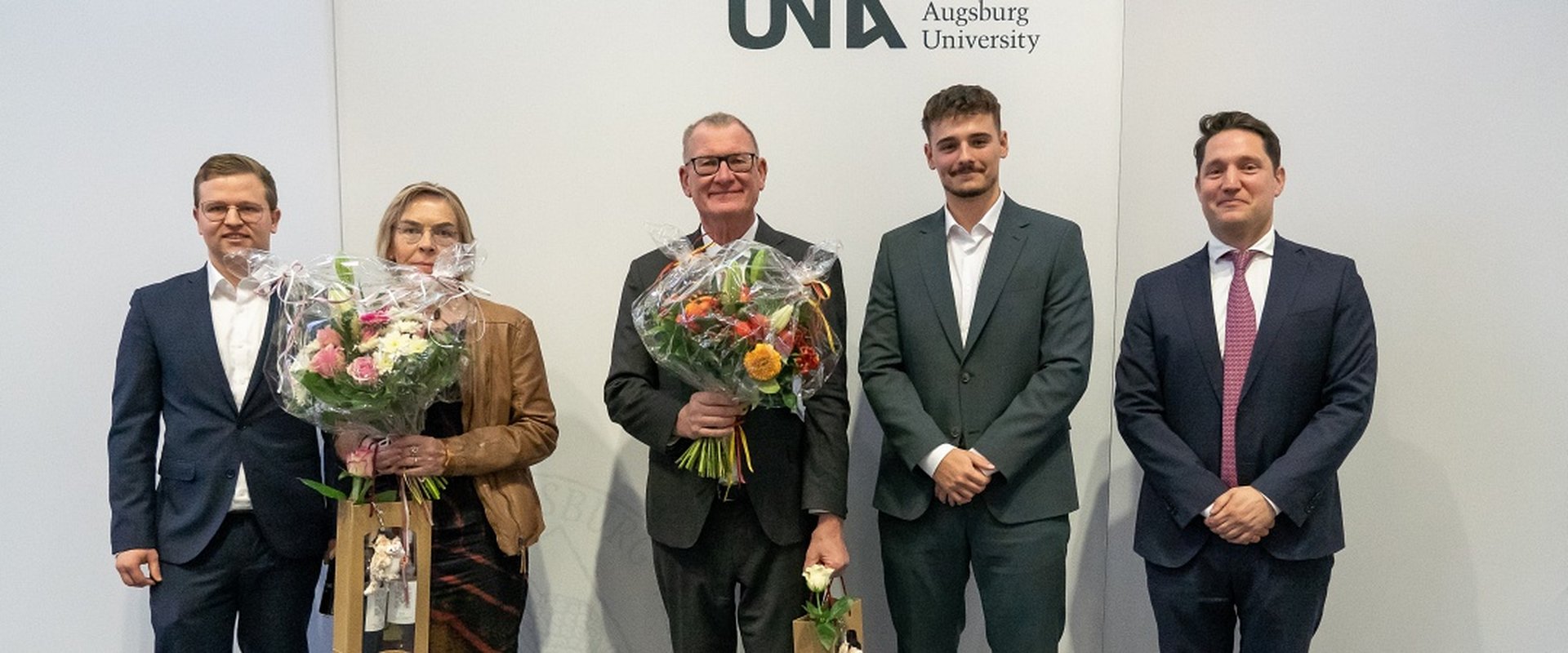 Absolventenfeier Rewi 2024. Professoren und Absolventen mit Blumensträußen.