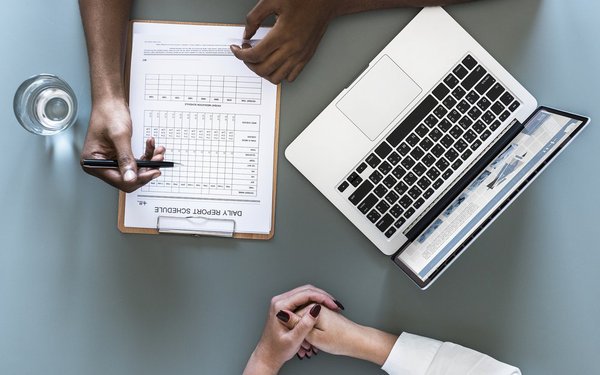 Schreibtisch mit Laptop und Klemmbrett