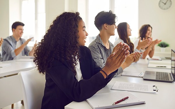 Schülerinnen und Schüler applaudieren im Seminarraum