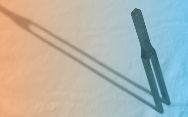 Stimmgabel im Schnee auf farbigem Hintergrund