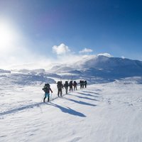 Bild einer Gruppe Menschen, die im Schnee wandern