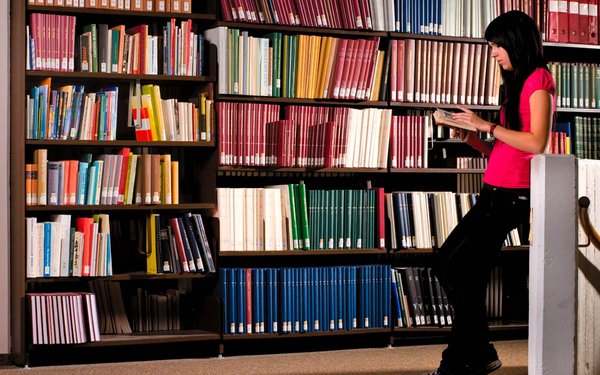 Studentin vor Bücherregal