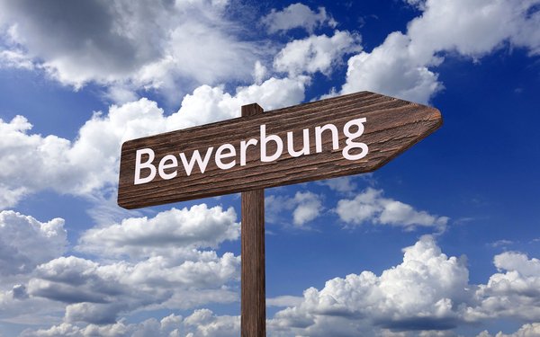 Ein Wegweiser auf dem Bewerbung steht, steht vor einem blauen Himmel