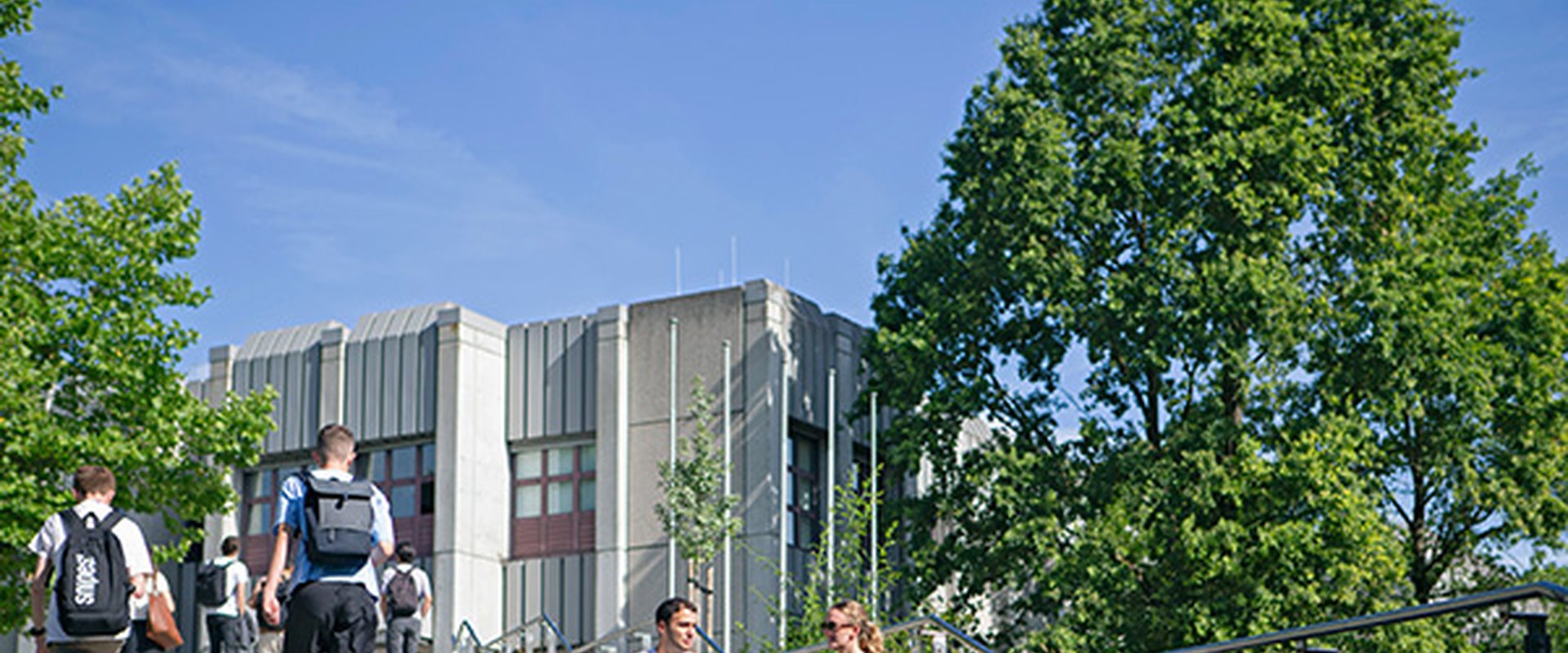 Studierende auf der Treppe vor der Bibliothek