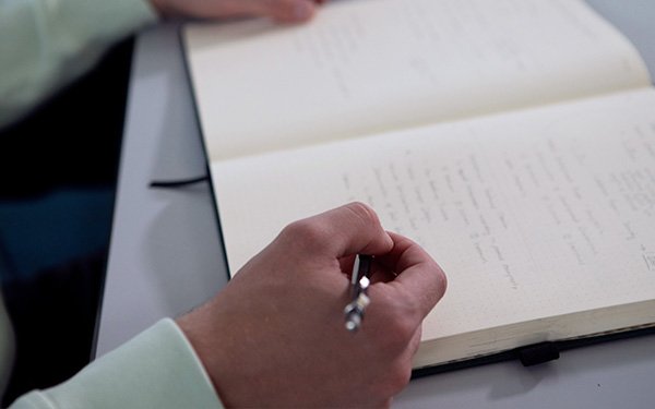 Nahaufnahme Notizblock mit Hand und Stift, Lernen, Arbeiten, Studieren