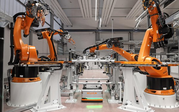 Im Smart Production Center der KUKA sieht man Roboterarme aufgereiht
