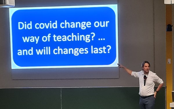 Ein Dozent steht neben einer Folie mit dem Text "Did Covid change our way of teachig and will it last?"