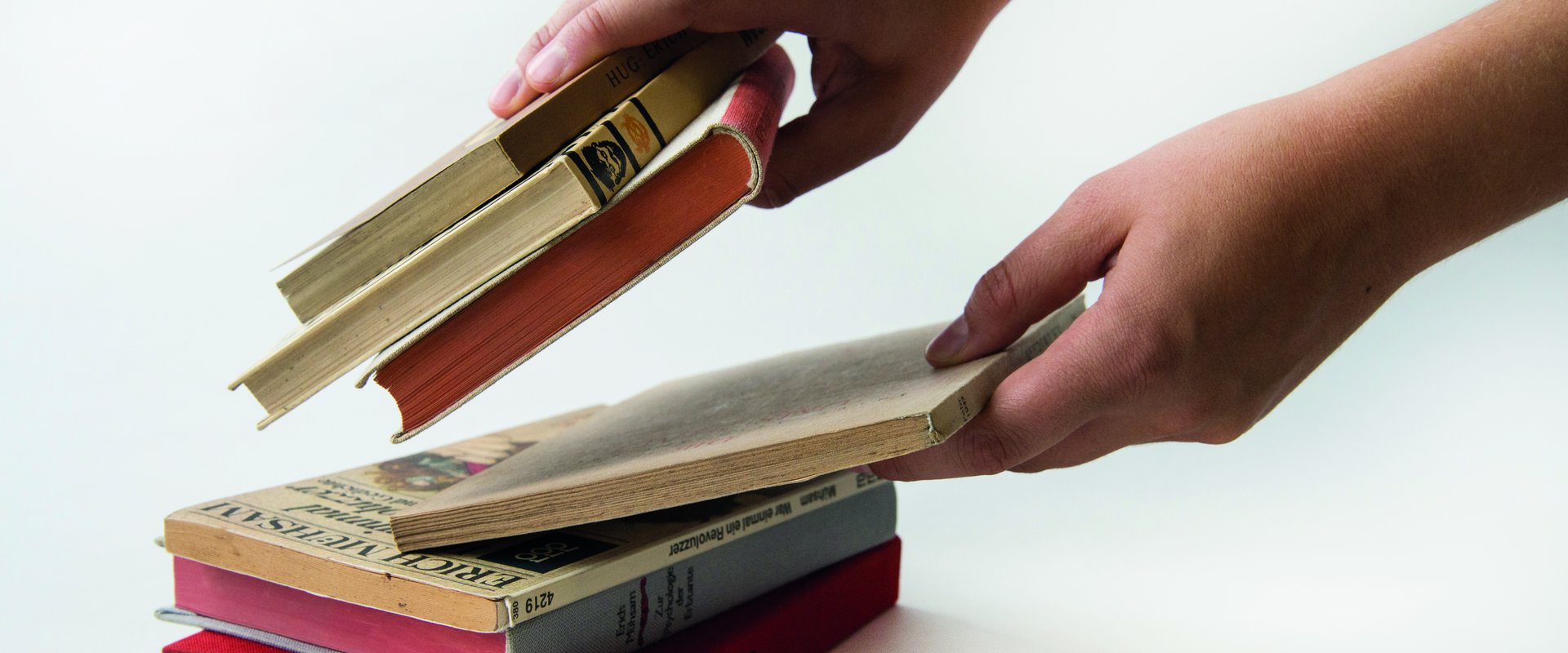 Hände sortieren Bücher aus der Sammlung Georg P. Salzmann