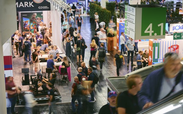Eine Messehalle der Gamescom mit vielen Besuchern an Messeständen.