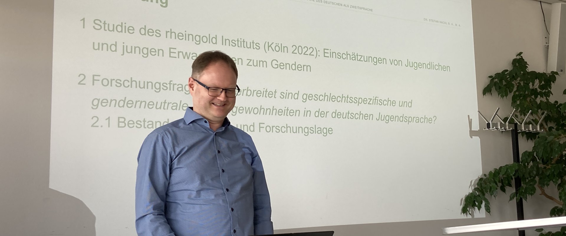 Es ist ein Bild von Stefan Hackl bei seinem Vortrag zu sehen