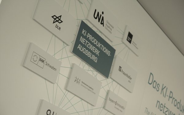Partnerwand des KI-Produktionsnetzwerks im Showroom