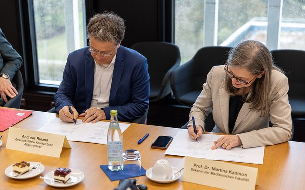 Andreas Ruland, Geschäftsführer des Klinikverbunds Allgäu, und Prof. Dr. Martina Kadmon, Medizindekanin der Universität Augsburg, legen den Grundstein für weitere Standorte für die Praxisausbildung zukünftiger Ärztinnen und Ärzte in der Region.