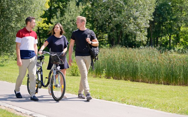 Studierende mit Fahrrad am See