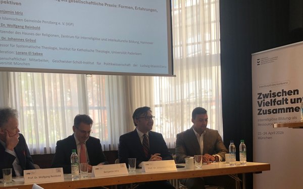 Podiumsdiskussion mit vier Personen am Tisch sitzend