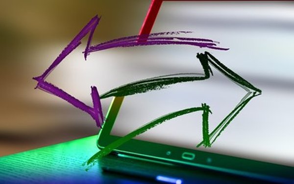 Ein lilaner und grüner Pfeil zeigen in entgegengesetzte Richtungen, dahinter sieht man verschwommen ein Tablet.