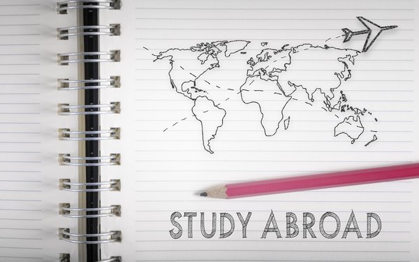Block mit Weltkarte und den Worten "Study Abroad"