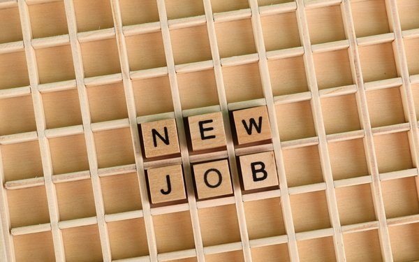 setzkastenartiges Holzbrett in auf dem Buchstaben liegen, die die Wörter "New Job" ergeben